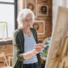 Elderly lady painting on a canvas