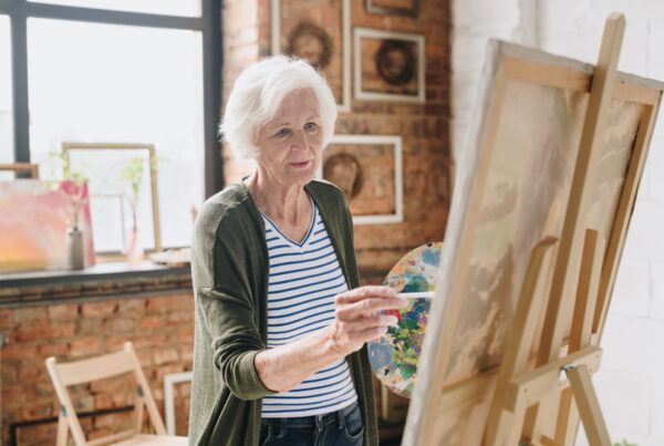 Elderly lady painting on a canvas