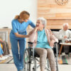 Nurse in aged care facility talking to an older lady in a wheelchair