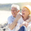Older couple laughing on the beach